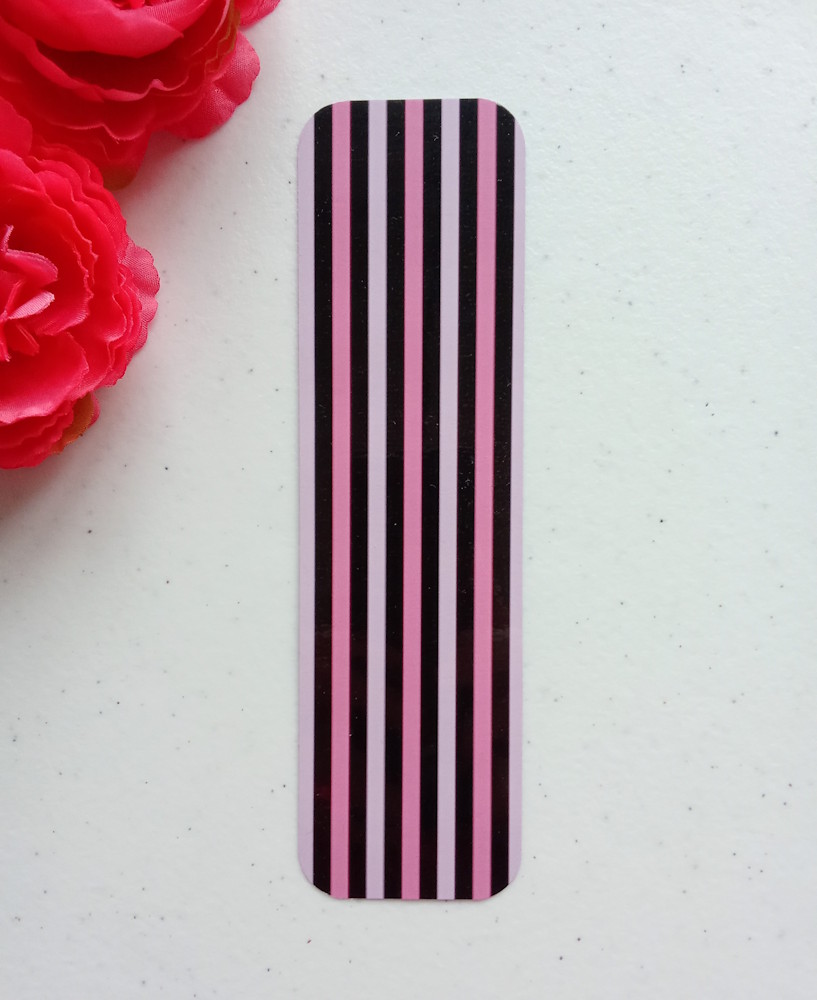 Marcapáginas grande con diseño de rayas finitas. Laminado, impreso a doble cara, esquinas redondeadas. Colores negro y rosa.