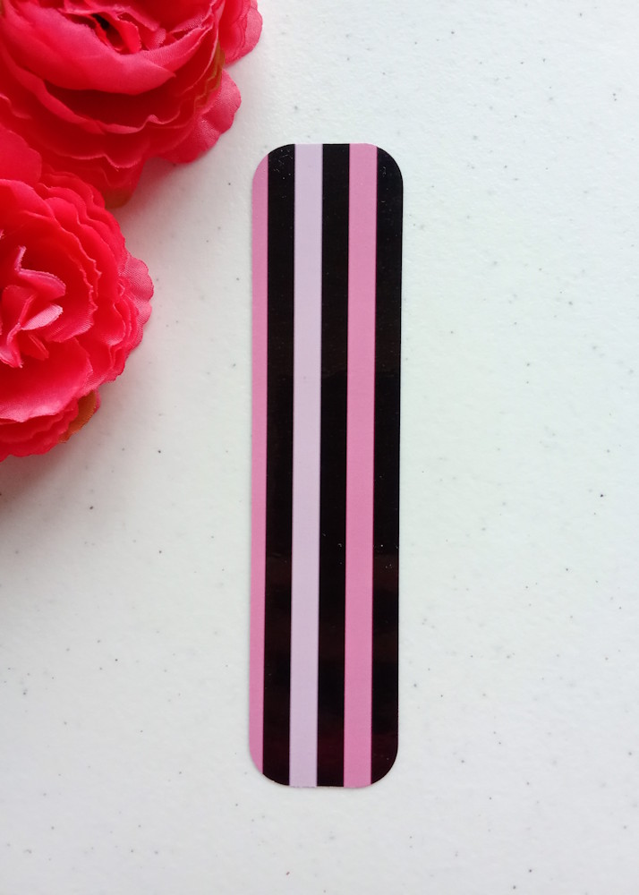Marcapáginas pequeño con diseño de rayas. Laminado, impreso a doble cara, esquinas redondeadas. Colores negro y rosa.